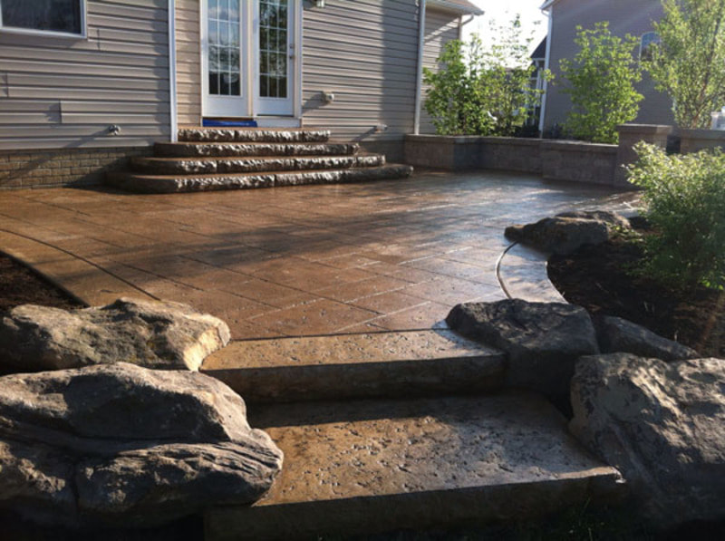 back patio stamped concrete with boulders 