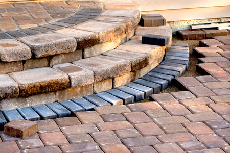 Paving with bricks to create unique stairs in backyard patio